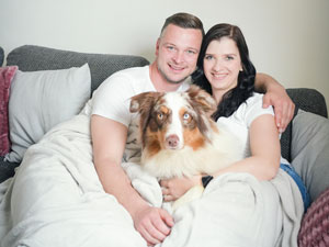 Glückliches Paar mit Familienhund auf der Couch